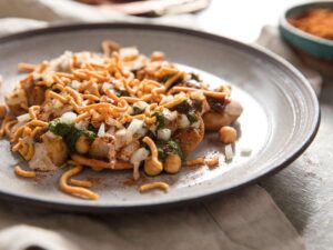 Close‑up of chaat with tamarind sauce drizzled on top.
