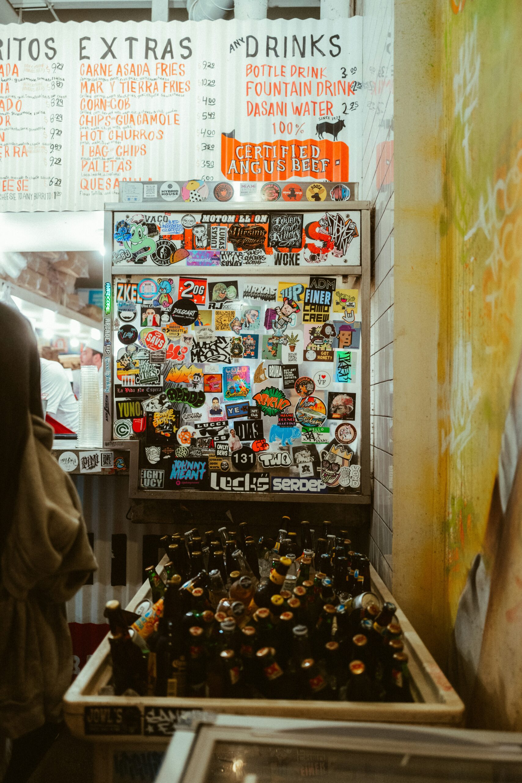 A cooler packed with ice and beer at a Mexican taco stand